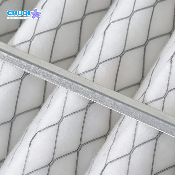 Close-up of wire-backed non-woven synthetic polyester filter media capturing 5-micron dust particles in industrial air systems